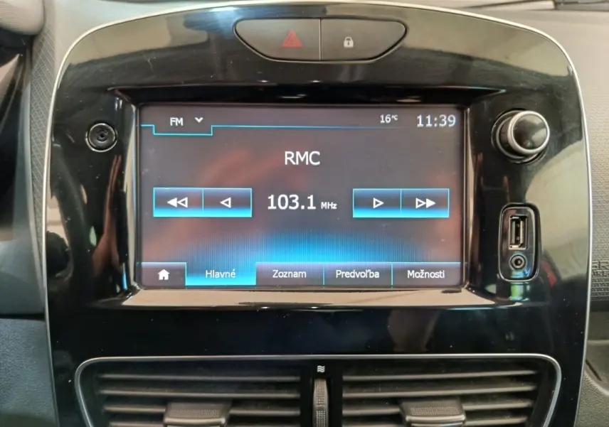 Écran tactile central de la Renault Clio Intens 2018 affichant une radio FM, entouré de commandes noires brillantes.
