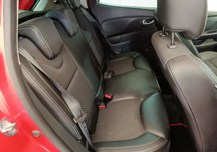 Vue intérieure côté gauche montrant la banquette arrière en cuir noir de la Renault Clio rouge 2018.