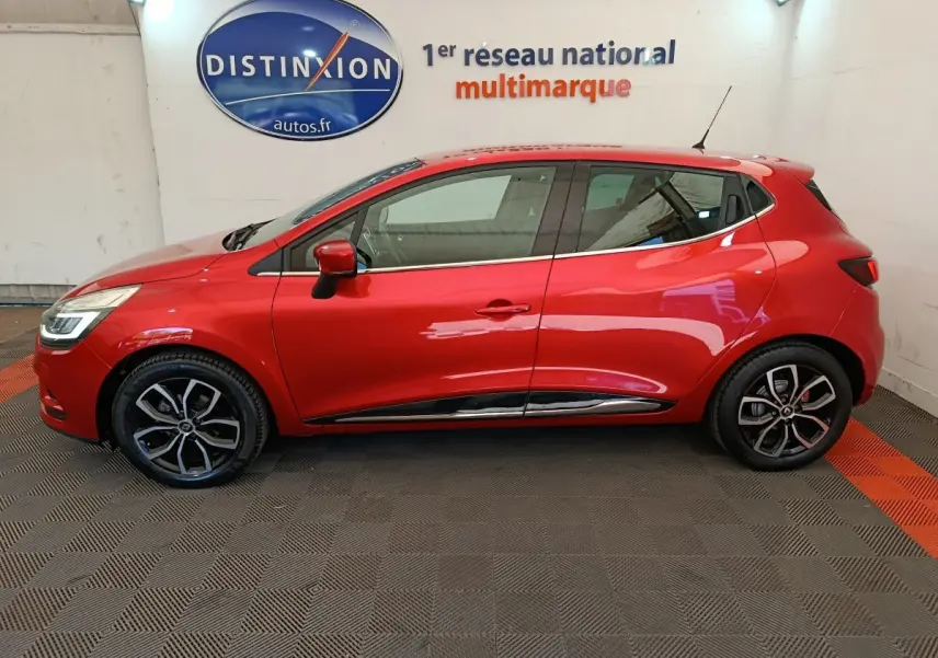 Profil côté gauche d'une Renault Clio Intens Energy TCe 90 rouge de 2018, avec jantes alliage et rétroviseurs assortis.