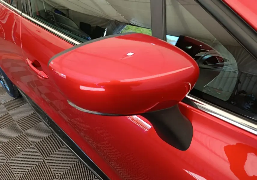 Gros plan sur le rétroviseur droit rouge brillant de la Renault Clio Intens Energy TCe 90 de 2018.