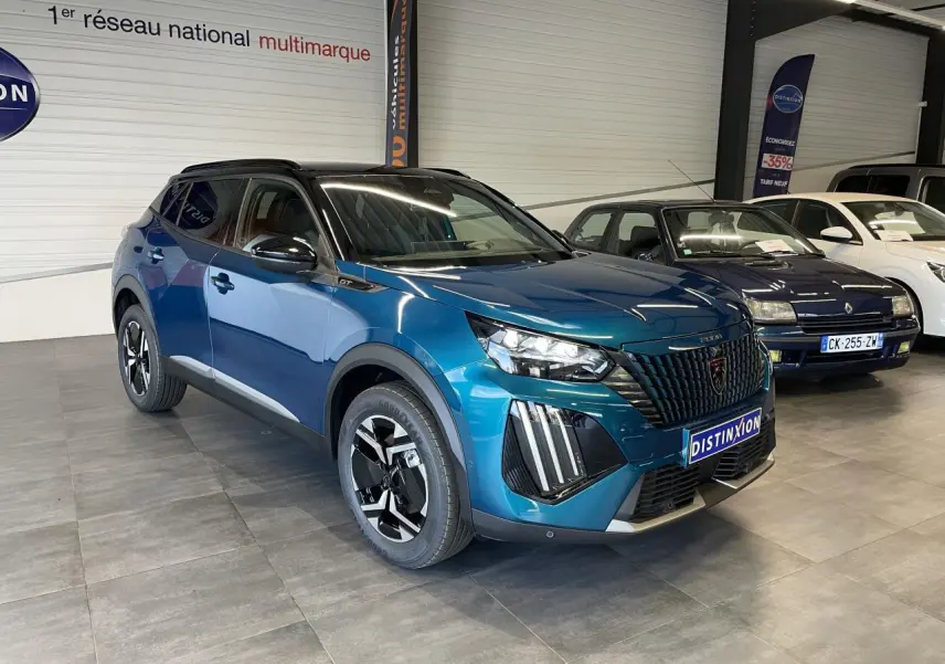 Peugeot 2008 1.2i Hybrid GT 2026 bleu, vue 3/4 avant avec calandre noire et toit noir brillant.