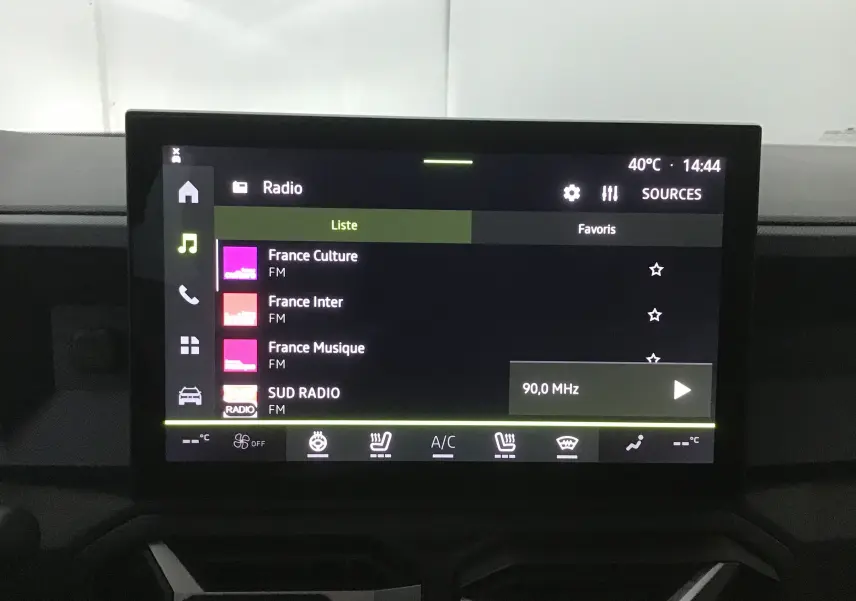 Écran tactile central du tableau de bord du Dacia Bigster 2025 affichant les stations radio FM avec interface moderne.
