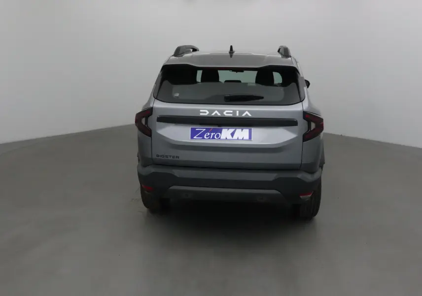 Vue arrière du SUV Dacia Bigster gris schiste 2025 avec logo lumineux et feux arrière en forme de C.