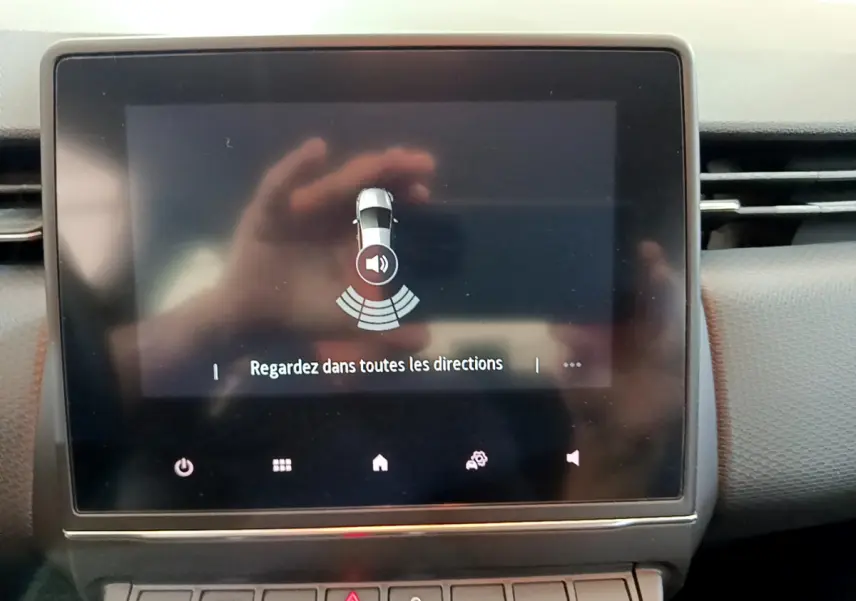 Écran tactile central affichant l'alerte de détection d'obstacles dans une Renault Clio Business blanche de 2021.