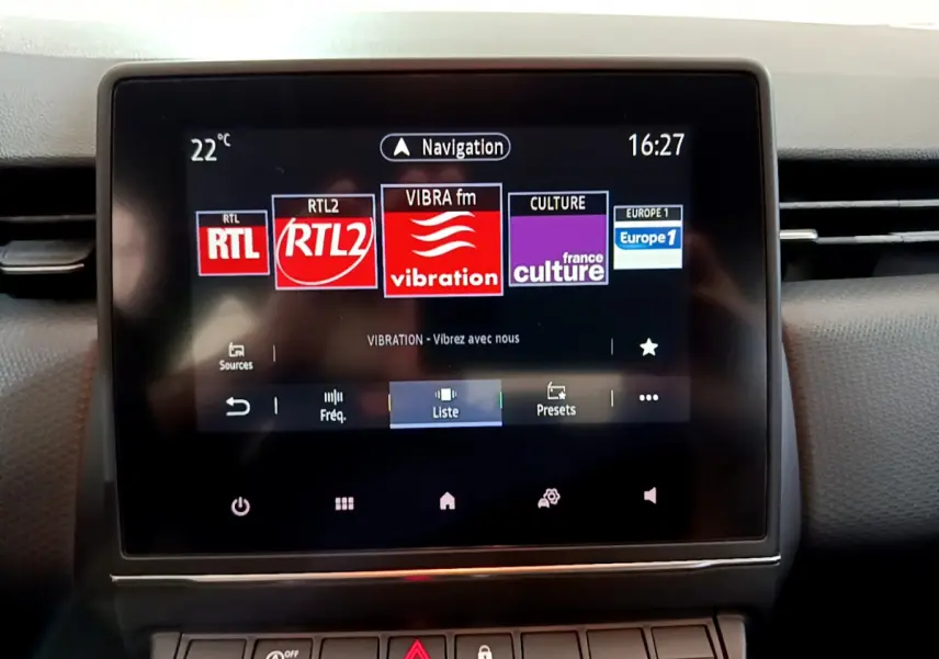 Écran tactile central de la Renault Clio Business 2021 affichant les stations radio et la navigation, vue frontale rapprochée.