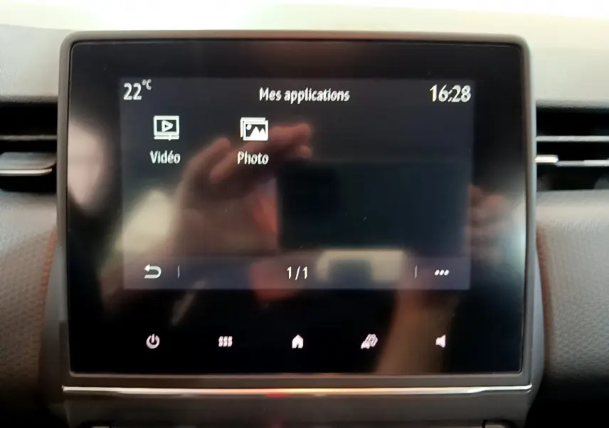 Écran tactile central de la Renault Clio Business blanche 2021 affichant les applications vidéo et photo.