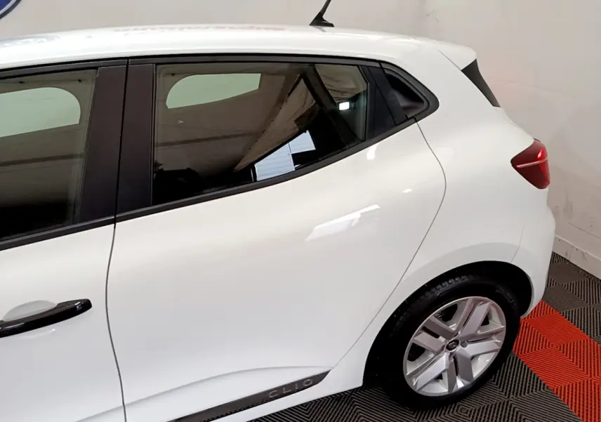 Vue latérale droite d'une Renault Clio Business blanche, mettant en valeur la ligne de caisse et la jante alliage.