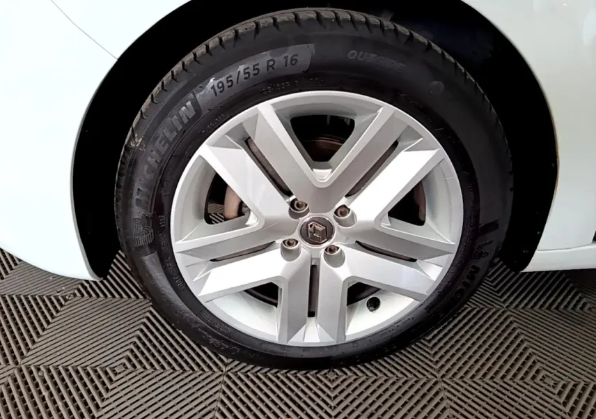 Gros plan sur la roue avant droite blanche d'une Renault Clio Business 2021 avec jante alliage et logo Renault central.