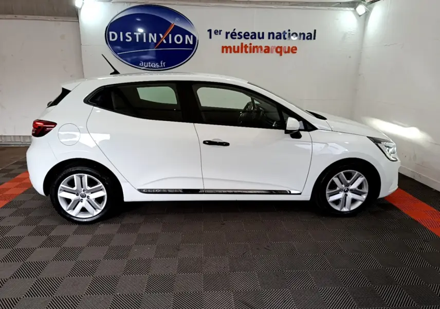 Profil droit d'une Renault Clio Business blanche 2021, avec jantes alliage et poignées de porte noires visibles.
