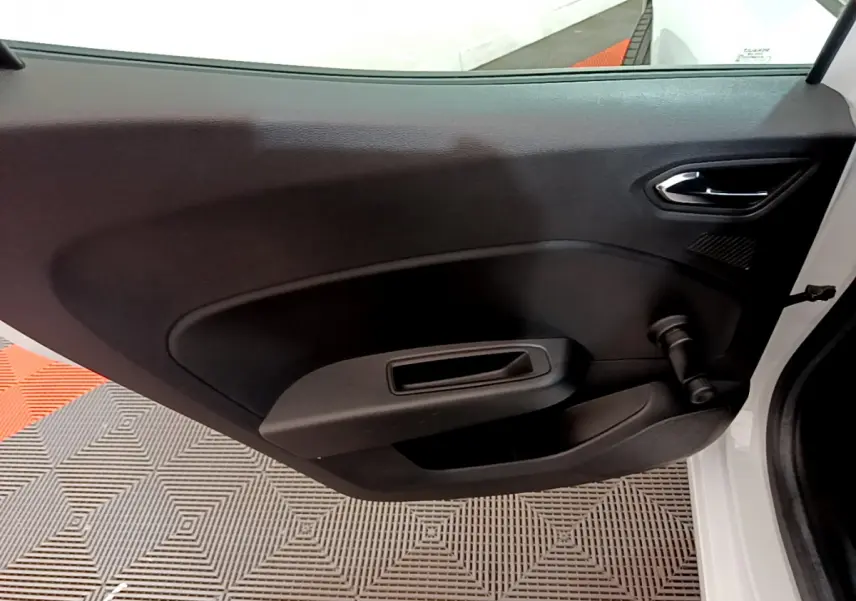 Vue intérieure de la porte avant droite noire d'une Renault Clio Business blanche avec poignée manuelle de vitre.