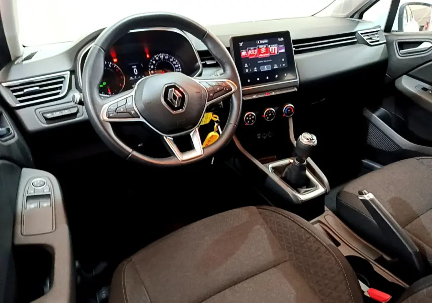 Intérieur de Renault Clio Business 2021 vu côté conducteur, volant cuir, écran tactile central et boîte manuelle noire.