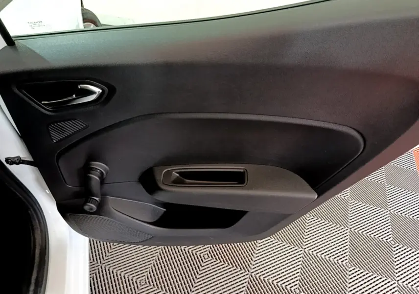 Vue rapprochée de la porte intérieure côté gauche noire de la Renault Clio Business blanche, avec manivelle de vitre visible.