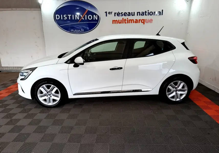 Profil droit d'une Renault Clio Business blanche 2021, avec jantes alliage et poignées noires, en intérieur showroom.