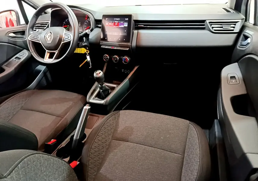 Intérieur avant de la Renault Clio Business 2021, vue côté conducteur, volant cuir et écran tactile central allumé.