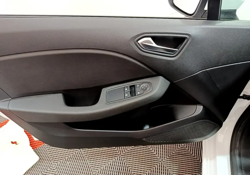 Vue rapprochée de la porte avant gauche blanche de la Renault Clio Business avec commandes électriques et poignée argentée.