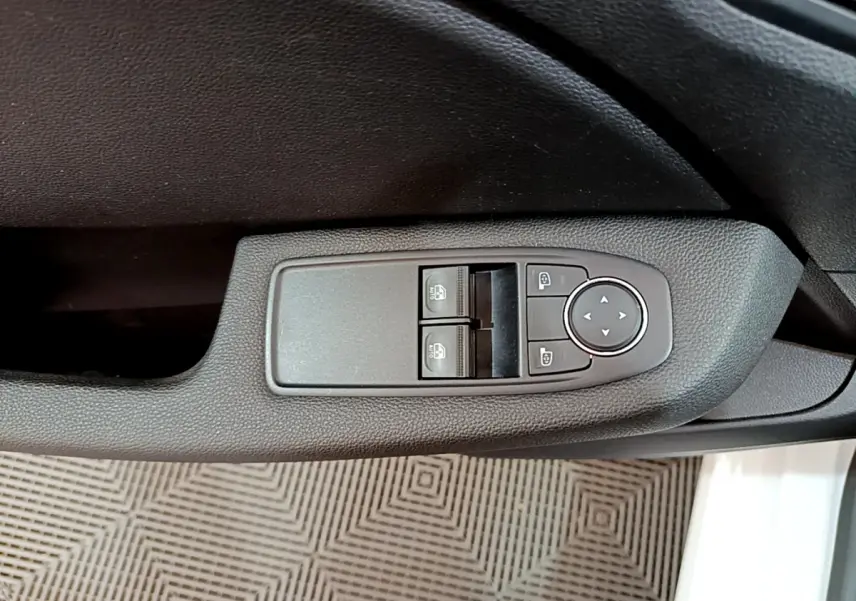 Gros plan sur les commandes de lève-vitres et réglage des rétroviseurs côté conducteur de la Renault Clio Business blanche 2021.