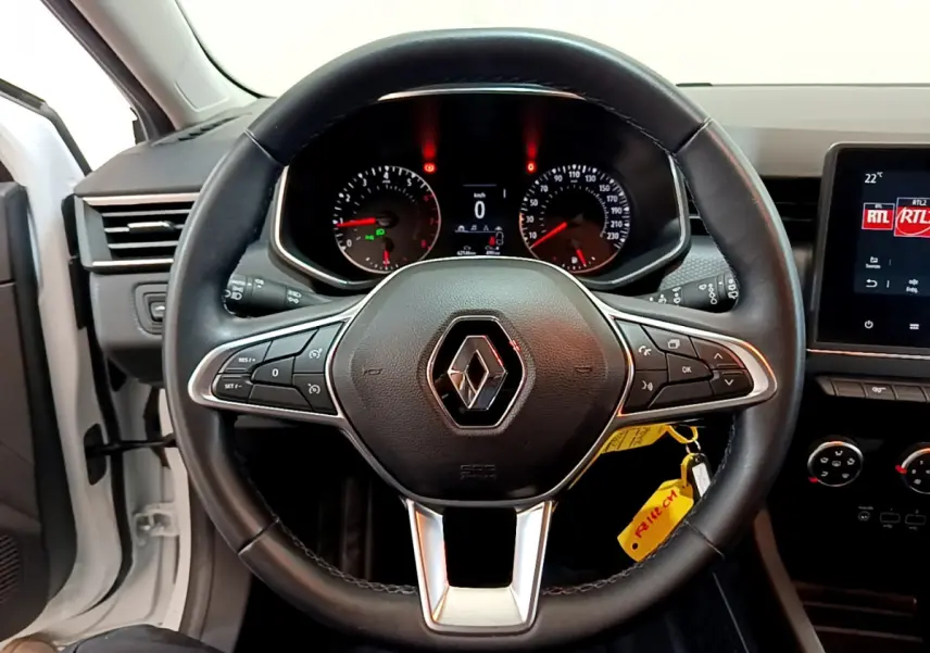 Vue centrée sur le volant cuir noir de la Renault Clio Business blanche 2021 avec tableau de bord et écran tactile visibles.