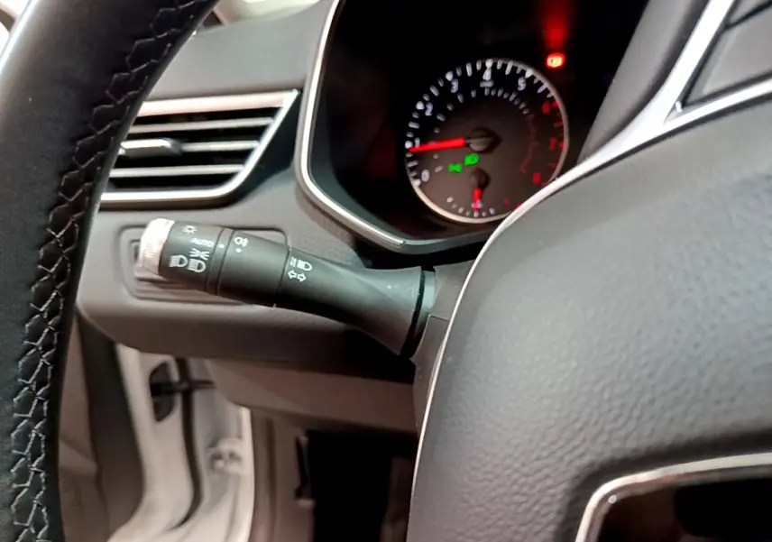 Gros plan sur la manette des phares et le compteur de vitesse du tableau de bord de la Renault Clio Business blanche 2021.