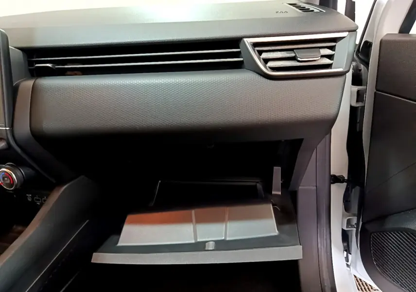 Intérieur côté passager d'une Renault Clio Business blanche 2021, boîte à gants ouverte et tableau de bord gris.