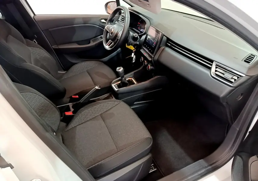Intérieur avant droit de la Renault Clio Business blanche, sièges noirs, volant cuir et écran tactile central visible.