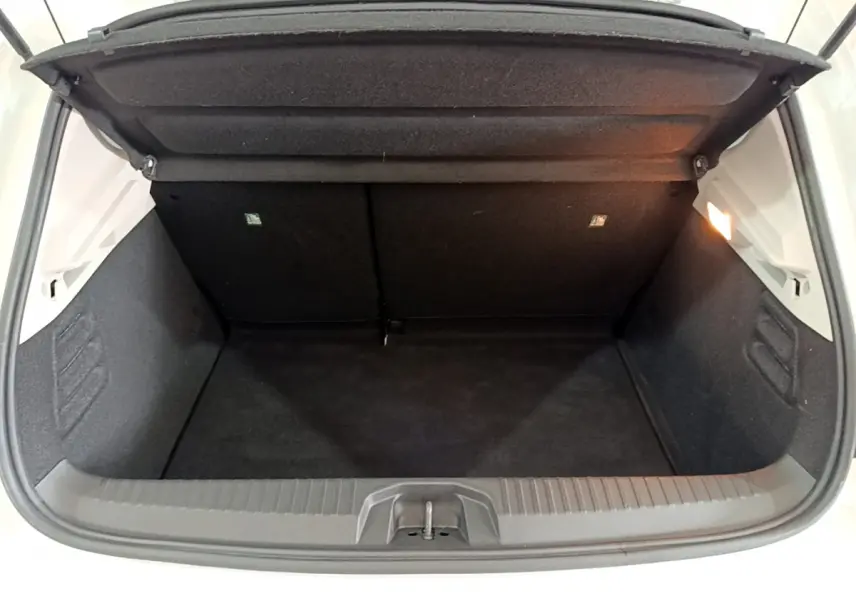 Coffre ouvert de la Renault Clio Business blanche 2021, vue arrière montrant l'espace de chargement vide et éclairé.