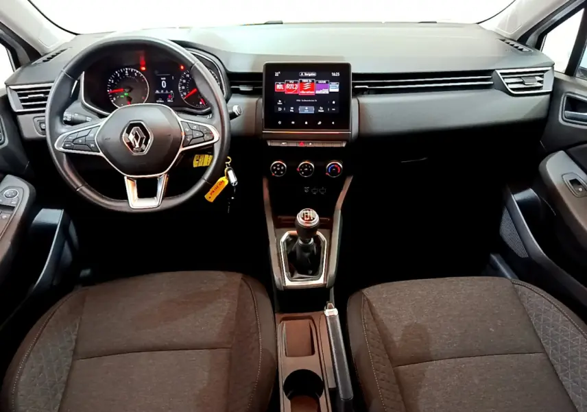 Vue intérieure avant de la Renault Clio Business blanche 2021, volant cuir, écran tactile et boîte manuelle visible.