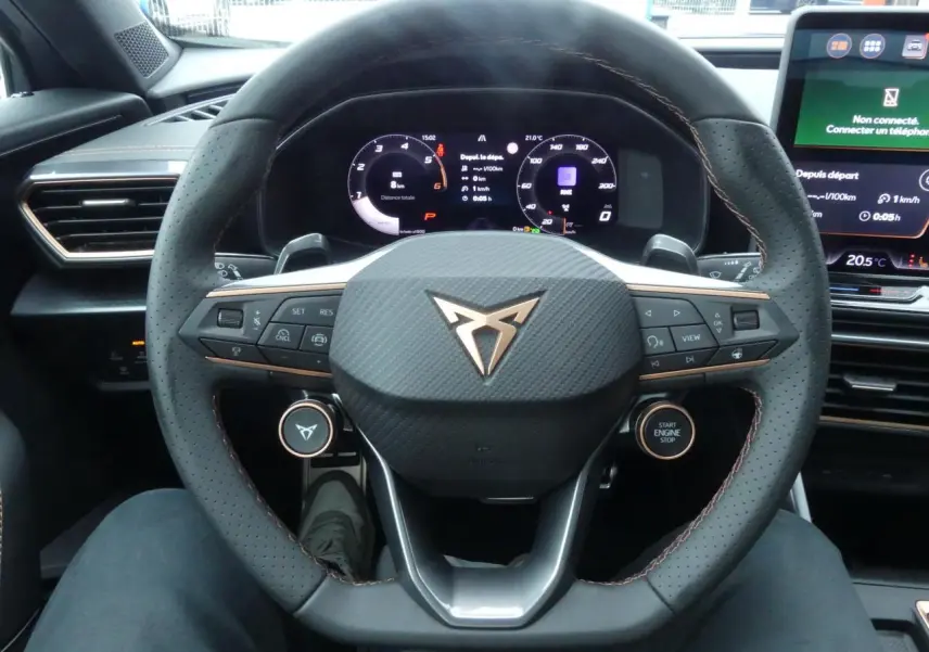 Vue rapprochée du volant perforé noir avec logo CUPRA cuivré et tableau de bord digital du Formentor Gris Graphène 2025.