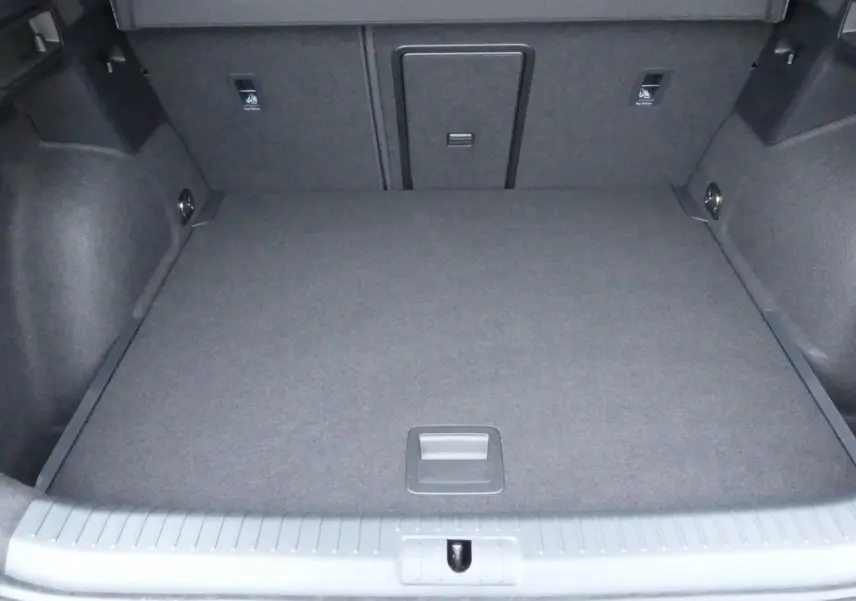 Coffre vide vu de face, revêtement gris foncé, avec trappe d'accès au siège arrière du CUPRA Formentor 2025.