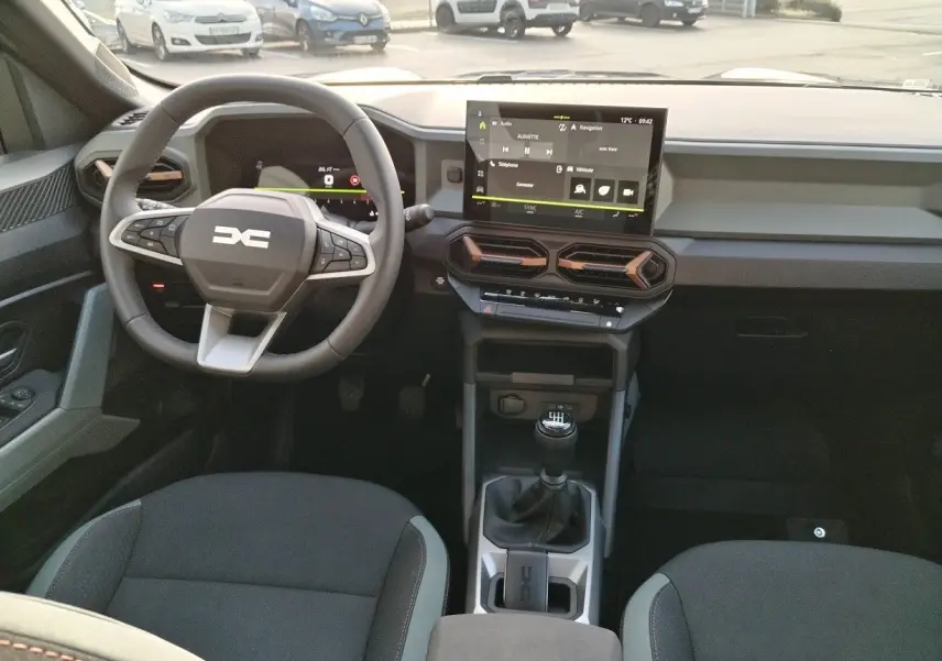Intérieur du Dacia Bigster 2025 en vue frontale, avec tableau de bord moderne et écran tactile central.