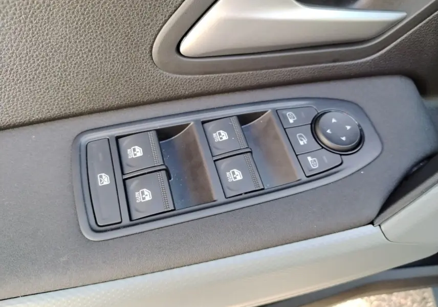 Panneau de commande des vitres électriques côté conducteur du Dacia Bigster noir, avec boutons de verrouillage et réglage des rétroviseurs.