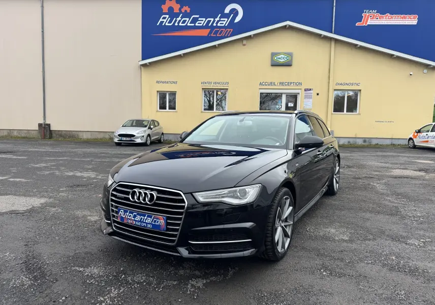 Audi A6 Avant noire vue 3/4 avant droit, avec calandre chromée et jantes alliage 19 pouces visibles.
