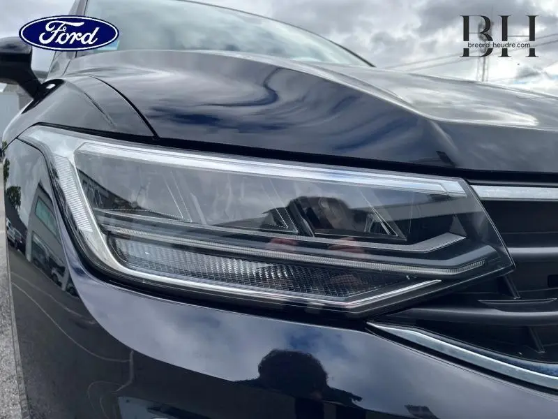 Gros plan sur le phare avant gauche du Volkswagen Tiguan noir intense nacrée, soulignant ses lignes LED modernes.