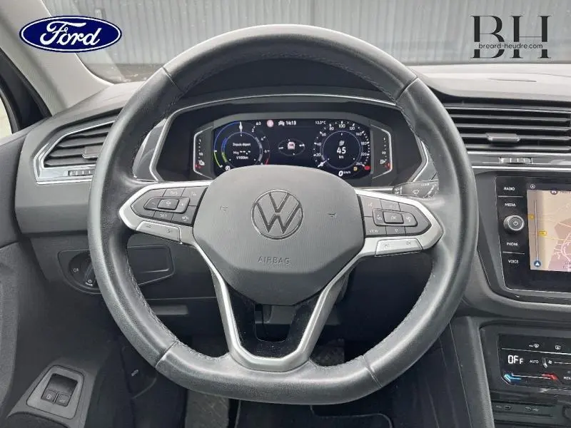 Vue intérieure centrée sur le volant cuir multifonction et le tableau de bord numérique du Volkswagen Tiguan noir intense nacré.