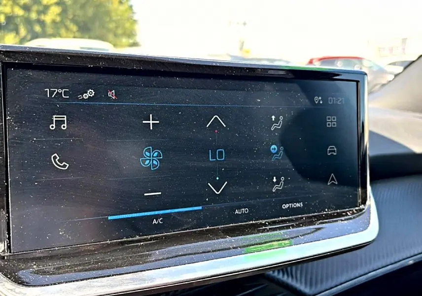 Écran tactile central affichant la climatisation dans l'habitacle d'un Peugeot 2008 gris, vue intérieure frontale.