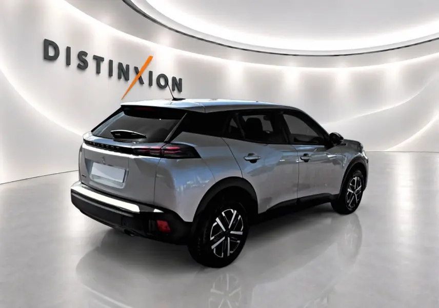 Peugeot 2008 gris en 3/4 arrière droit, avec feux arrière LED et becquet noir brillant.