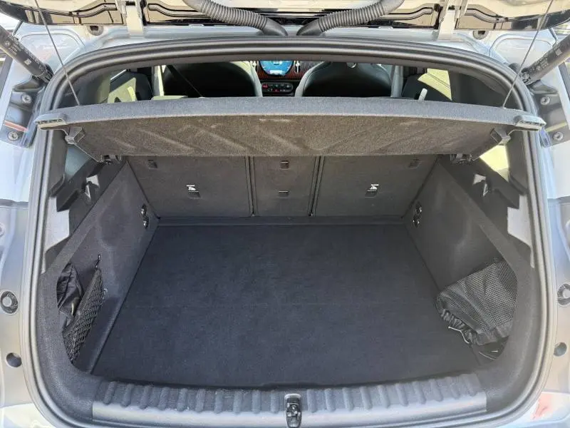 Coffre ouvert vu de l'arrière d'un MINI Countryman argenté 2025, montrant un espace de rangement propre et bien fini.