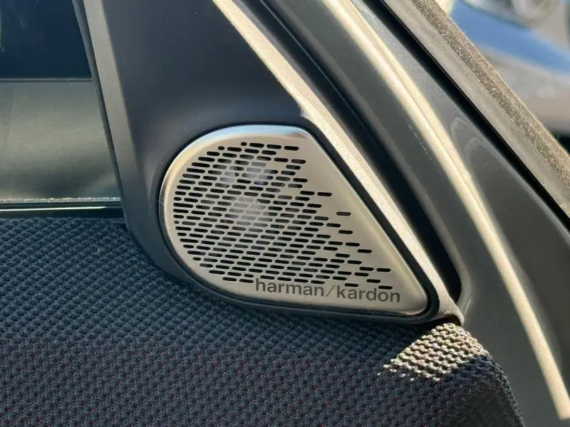 Gros plan sur le haut-parleur Harman Kardon intégré dans la porte intérieure côté avant droit d'une MINI Countryman argentée.