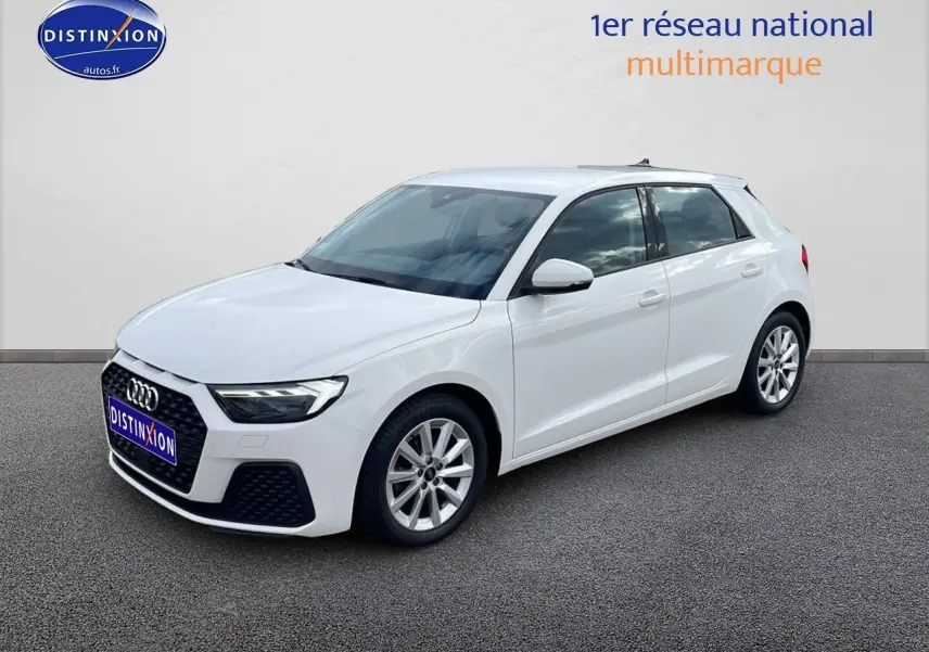Audi A1 Sportback blanc vue 3/4 avant droit avec jantes alu et phares LED allumés sur fond neutre.