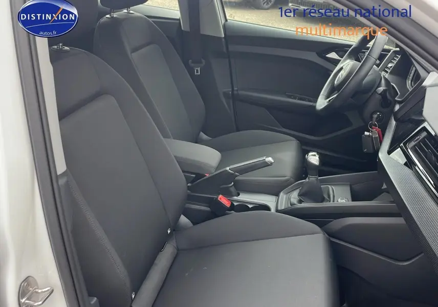 Intérieur avant noir de l'Audi A1 Sportback 30 TFSI 2022 vu côté gauche avec volant cuir et boîte manuelle.