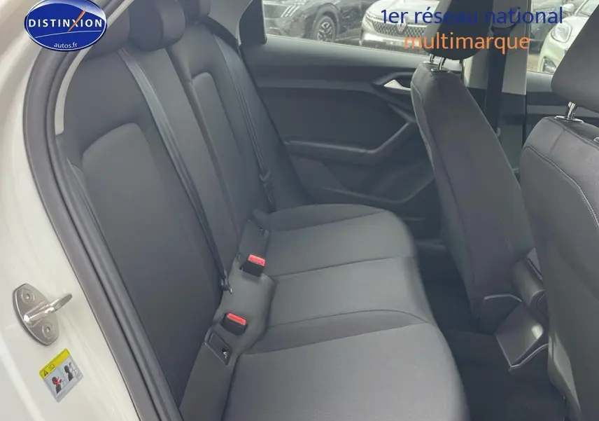 Vue intérieure côté gauche de la banquette arrière noire d'une Audi A1 Sportback blanche 2022.