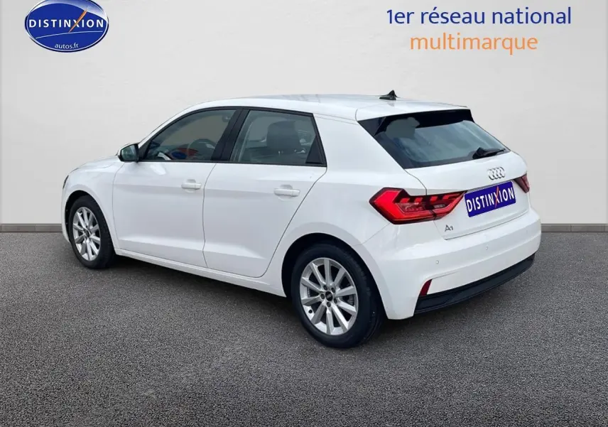 Audi A1 Sportback blanc vue 3/4 arrière côté gauche, avec jantes alu 16 pouces et feux arrière LED distinctifs.
