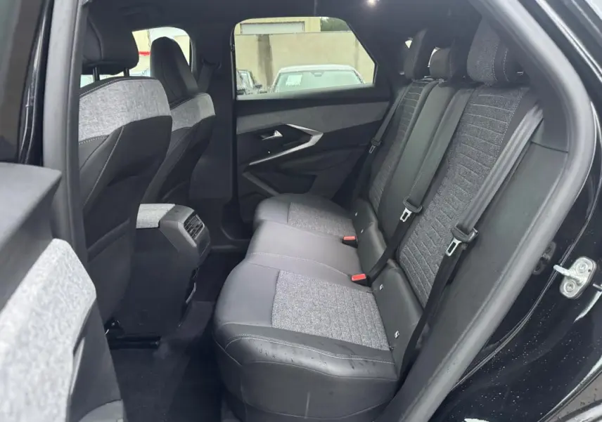 Vue intérieure arrière côté droit du Peugeot 3008 Hybrid 145 Allure 2025, sièges bi-matière gris et noir.
