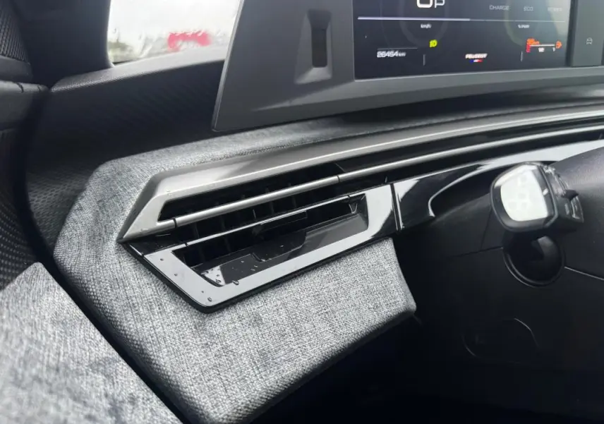 Détail de la sortie d’air côté gauche du tableau de bord gris clair du Peugeot 3008 Hybrid 145 e-DCS6 Allure noir 2025.