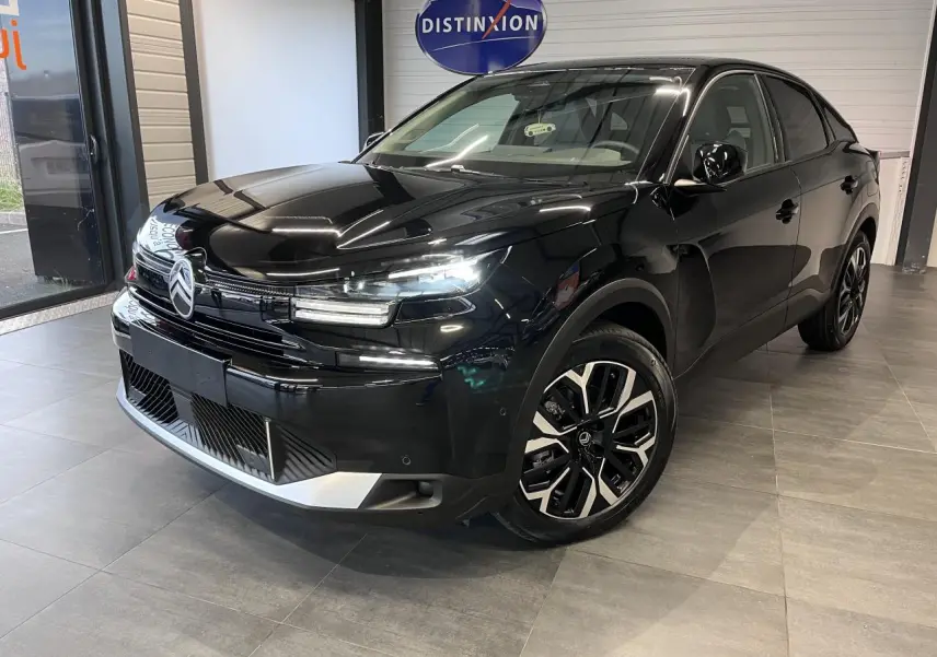 Vue 3/4 avant droite de la Citroën C4 2025 noire métallisée avec jantes alliage diamantées et signature lumineuse LED.