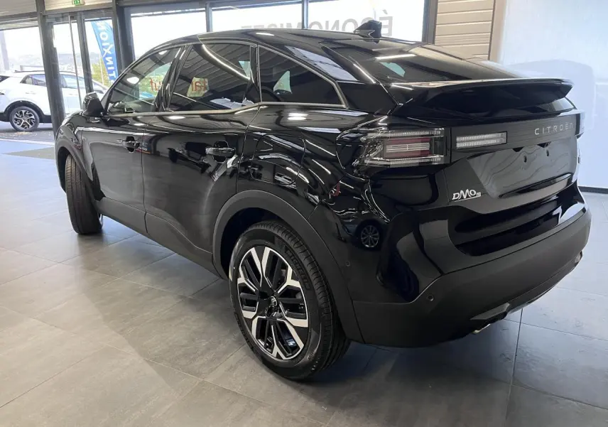 Vue 3/4 arrière droite d'une Citroën C4 noire métallisée avec jantes alliage 18 pouces et feux arrière LED.