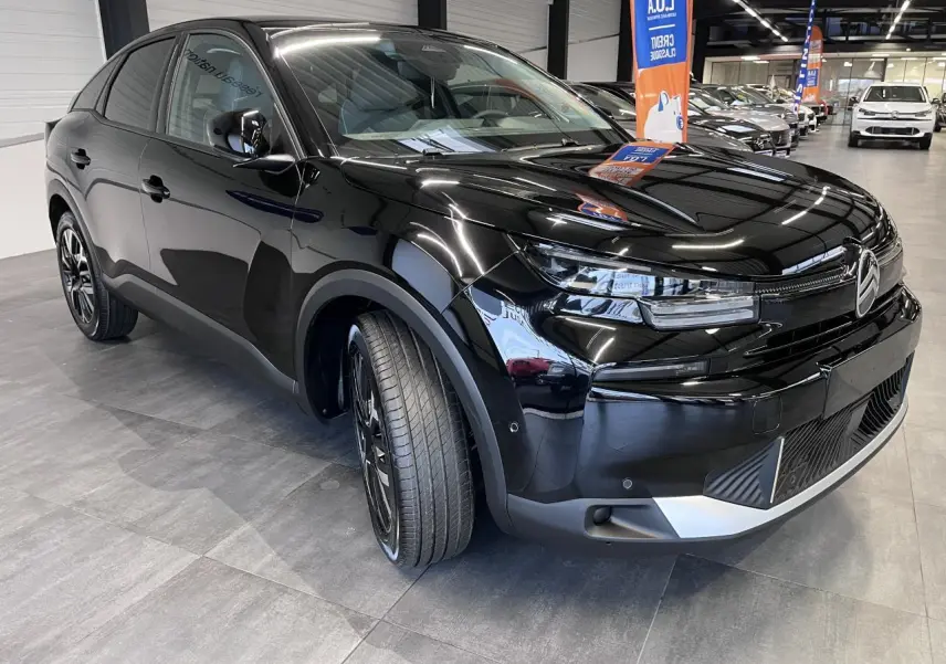 Vue 3/4 avant gauche d'une Citroën C4 noire métal avec jantes alliage et détails chromés au pare-chocs.