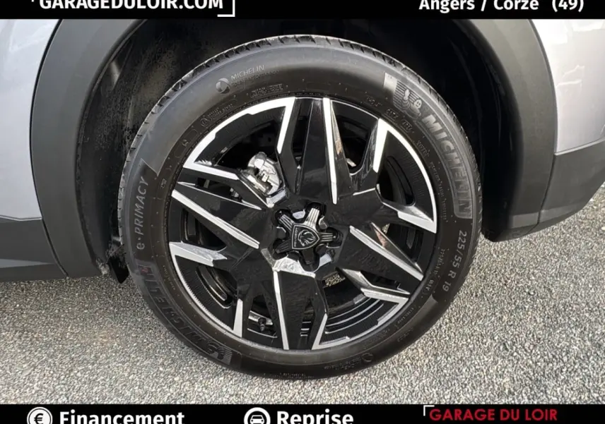 Gros plan sur la roue avant droite d’un Peugeot 3008 gris clair 2024, jante alliage noire et argentée distinctive.