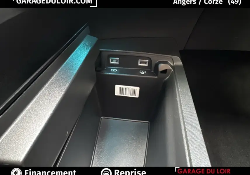 Gros plan sur la console centrale intérieure du Peugeot 3008 gris clair, montrant deux ports USB et un espace de rangement.
