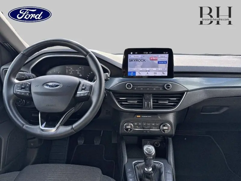 Vue intérieure avant de la Ford Focus 1.0 EcoBoost 2020, volant cuir multifonction et écran tactile central.