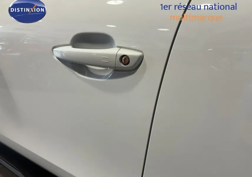 Poignée de porte blanche côté gauche d'une Citroën C4 2022 vue en gros plan intérieur garage.